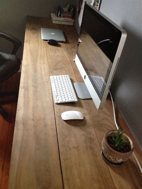 an apple computer sitting on top of a wooden desk next to a keyboard and mouse