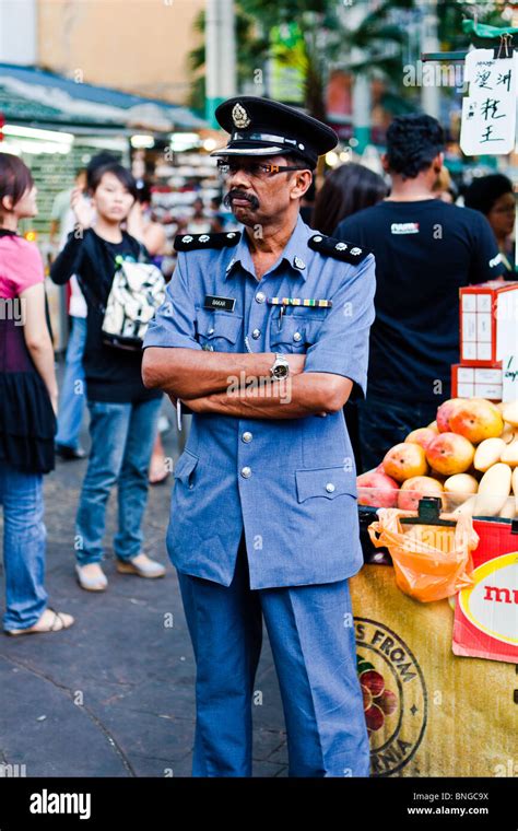 A Malaysian policeman watching the people in KL's Chinatown Stock Photo ...