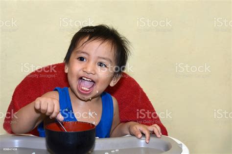 1 Year Old Baby Boy Learning To Eat Alone Smiling Stock Photo - Download Image Now - Asia, Asian ...