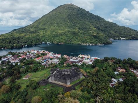 Premium Photo | Aerial fort belgica with banda neira fire volcano in ...