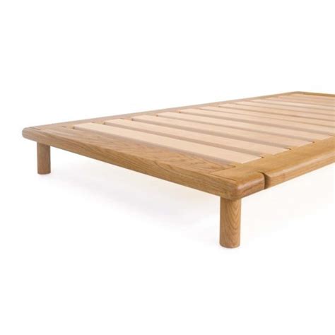 a wooden bed frame with slats on the top and bottom, against a white ...