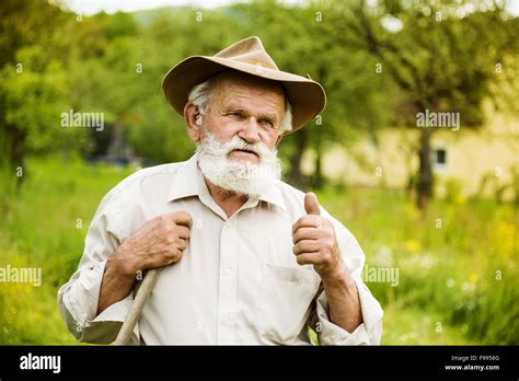 Old farmer with beard working with rake in garden Stock Photo - Alamy