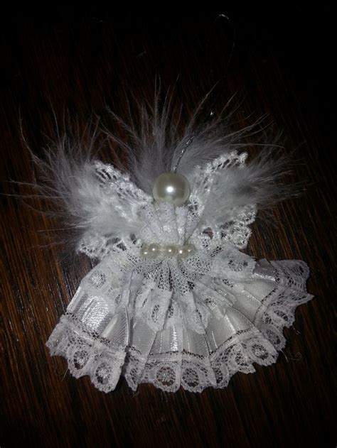 a white lace and pearl brooch with feathers on it's headband, sitting on a wooden surface