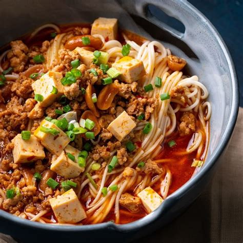 a bowl filled with noodles, meat and veggies