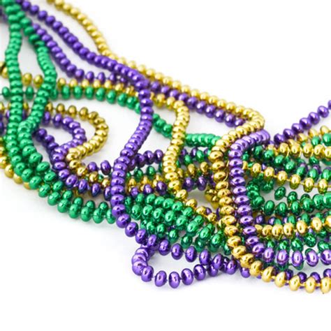 several beads are arranged together on a white surface and one bead is green, purple, and gold