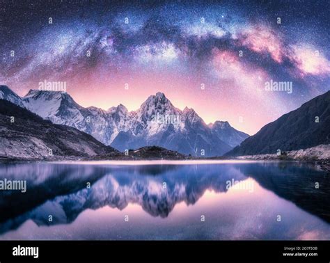 Milky Way over snowy mountains and lake at night Stock Photo - Alamy