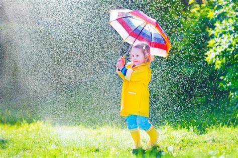 niño gracioso con paraguas jugando bajo la lluvia 831339 Foto de stock en Vecteezy