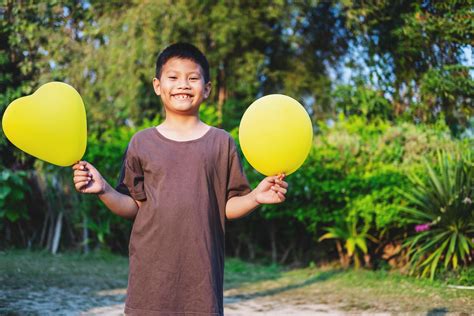 Happy boy holding yellow balloons 2230258 Stock Photo at Vecteezy