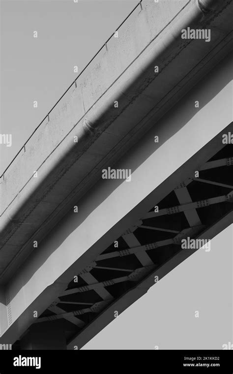 Minimalist view of an overhead modern concrete highway structure in a black and white monochrome ...