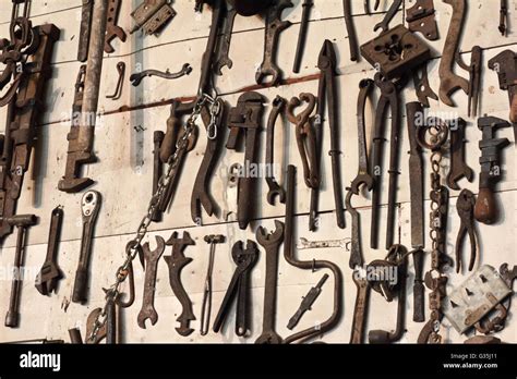 Antique tools hanging on a farm shop wall Stock Photo - Alamy