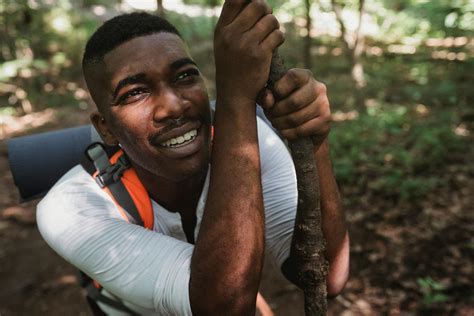 Tired African American man climbing up in forest · Free Stock Photo