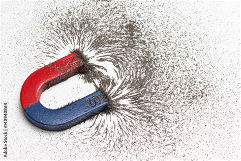 Red and blue horseshoe magnet or physics magnetic with iron powder ...