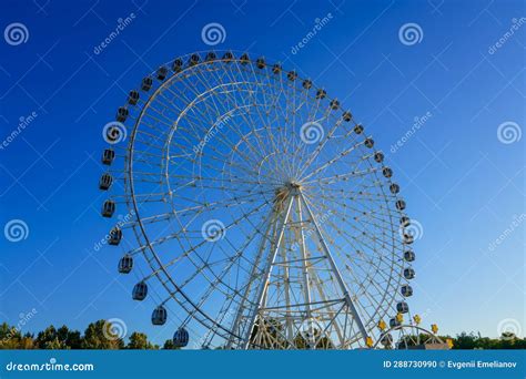 High Ferris Wheel at Sunset or Sunrise with Blue Sky in an Amusement ...