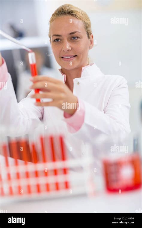 Attractive female chemical technician full test tubes with fluid using glass pipette Stock Photo ...