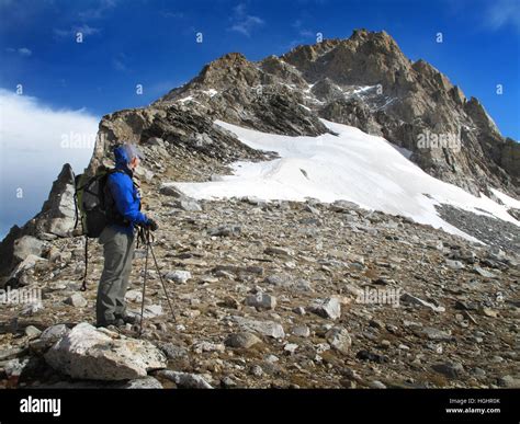 Man hiking climbing rugged mountain peaks in wilderness Stock Photo - Alamy