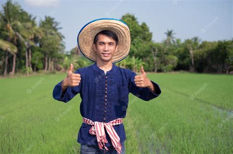 Premium Photo | Asian farmer man wear traditional costume standing and thumb up at green rice farm