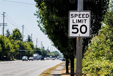 50 mph speed limit sign on post with a road and tree 15445866 Stock ...