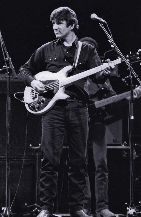 a man standing on top of a stage holding a guitar