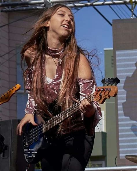 a woman with long hair playing an electric guitar