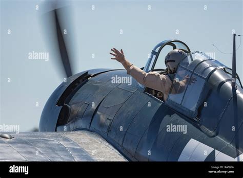 Pilot waiving from the cockpit of a Grumman F6F Hellcat fighter plane ...