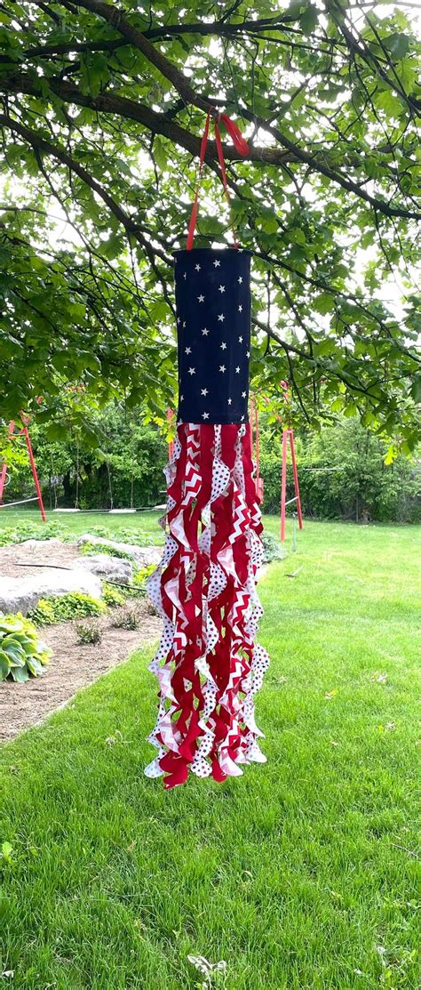 a red, white and blue flag hanging from a tree