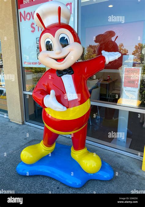 A Jollibee figure stood outside a fast food restaurant Stock Photo - Alamy