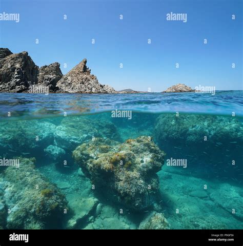 Rocky coast with rocks underwater, split view above and below surface, Mediterranean sea, Marine ...
