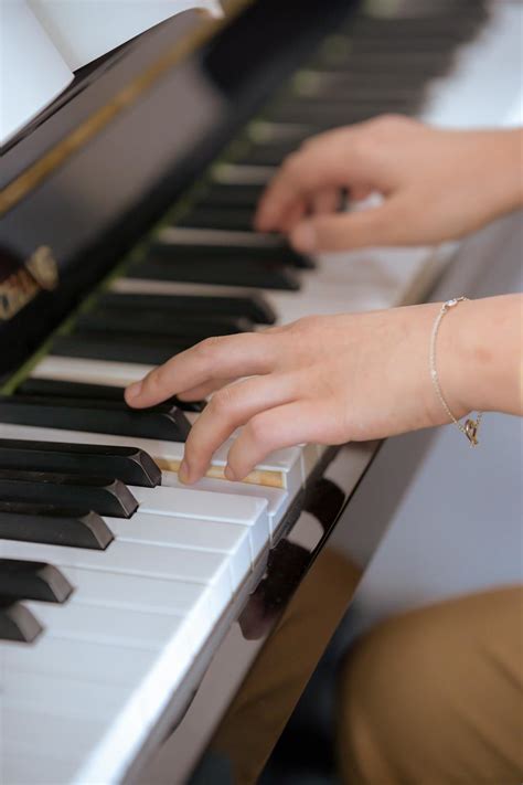 Young lady gently pressing piano keys · Free Stock Photo