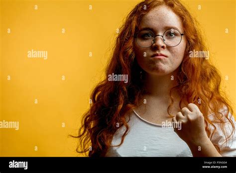 Young pretty ginger woman shows fist, with angry or aggressive expression Stock Photo - Alamy