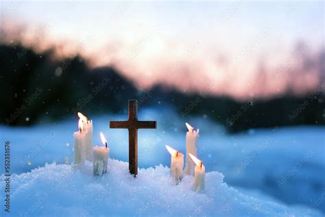 Christian cross and candles on snow, evening winter natural blurred ...