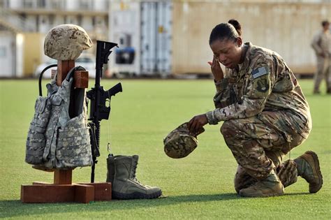 U.S. Air Force Master Sgt. Tiffany Robinson kneels in front of a battlefield cross following a ...