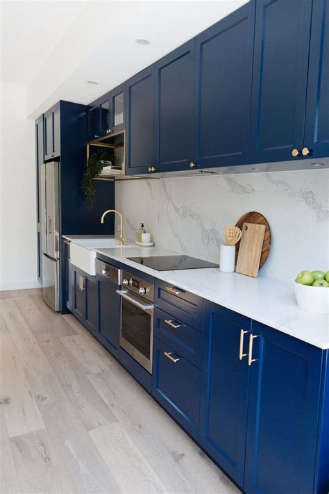 Navy blue kitchen with luxe brass accents and marble look benchtop | Integrated kitchen ...