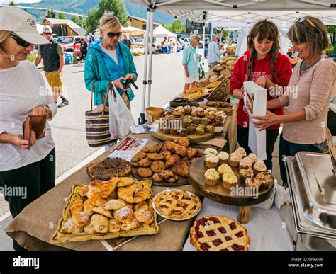 Customers & vendors buying bakery goods at weekly summer farmers market; Crested Butte; Colorado ...