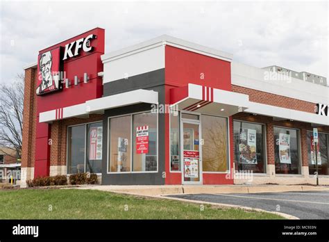 A logo sign outside of a KFC (Kentucky Fried Chicken) fast food ...