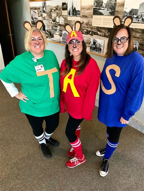 three women dressed up in costumes standing next to each other on the ...