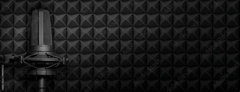 Dark podcast or recording studio background with acoustic foam and black microphone. Audio ...