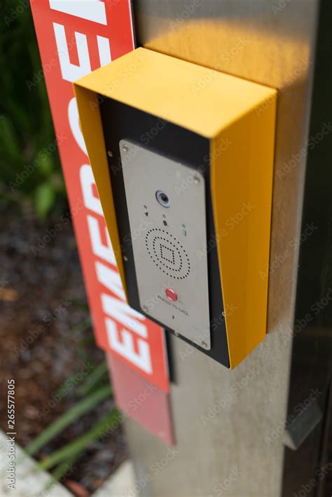 a close up photograph of an emergency button telephone intercom system on the side of a public ...