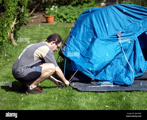 A camper setting up his tent on campsite Stock Photo - Alamy