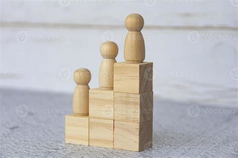 Wooden people figures on top of wooden blocks. Career growth concept ...