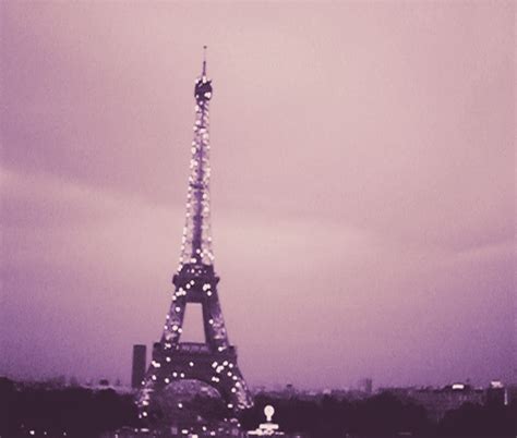 the eiffel tower is lit up at night