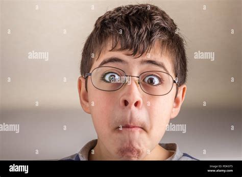 Boy sucks cheeks and squeezes his lips making weird face as a sign of ...