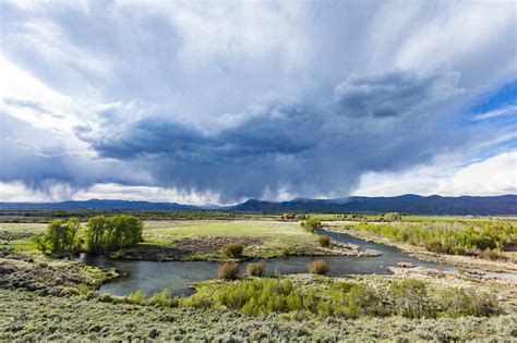 Usa, Idaho, Bellevue, Storm clouds above green field with creek stock photo