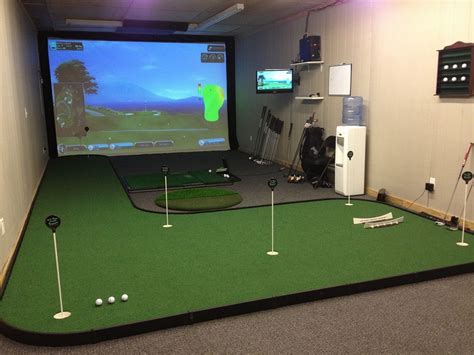 an indoor golf simulator is set up in a room with green carpet and white walls