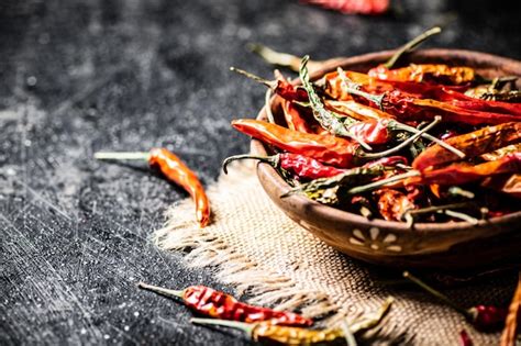 Premium Photo | Pods of dried chili peppers in a wooden plate on a napkin