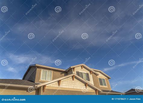 Home with Front Gable Roof and Dormers Against Vast Blue Sky with ...