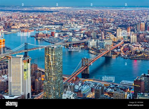 Brooklyn and Manhattan bridges span East River at dusk, between ...