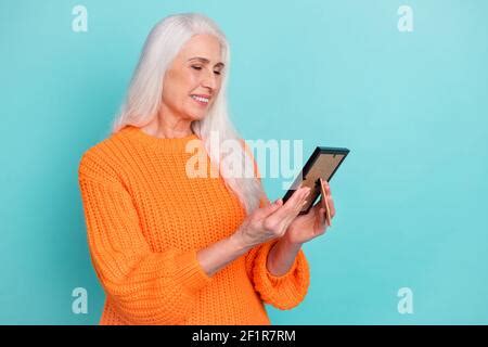 Photo of charming dreamy senior lady dressed yellow blazer glasses typing gadget looking empty ...