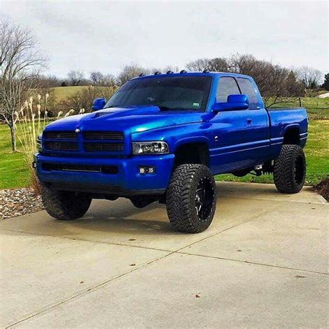 a large blue truck parked on top of a driveway