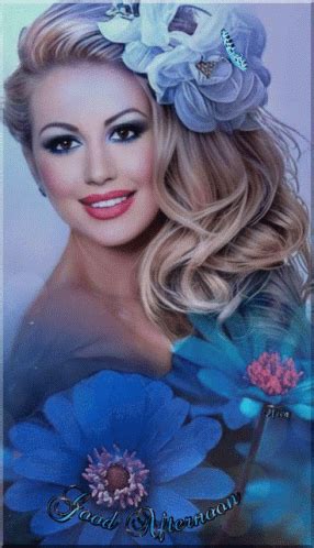 a woman with long blonde hair and blue flowers in her hair is smiling at the camera