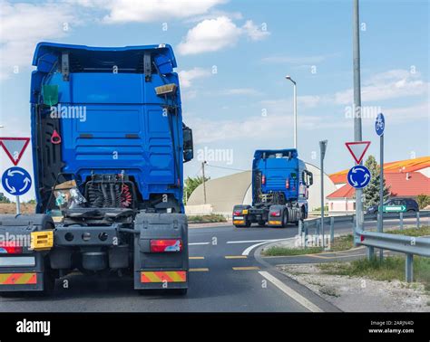 Two new blue semi truck cab. Big powerful tractors go to the roundabout ...